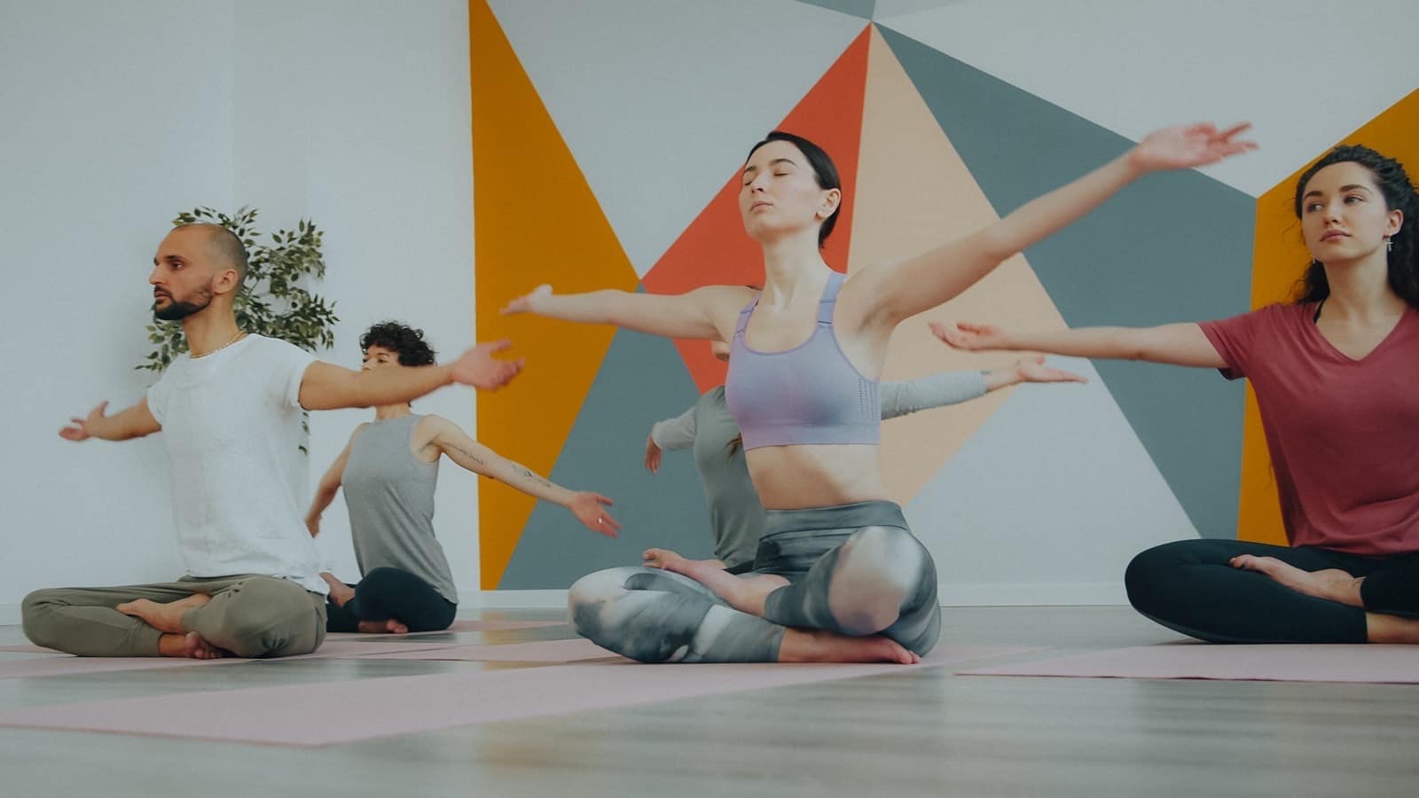 Clase de yoga en un estudio con la pared pintada